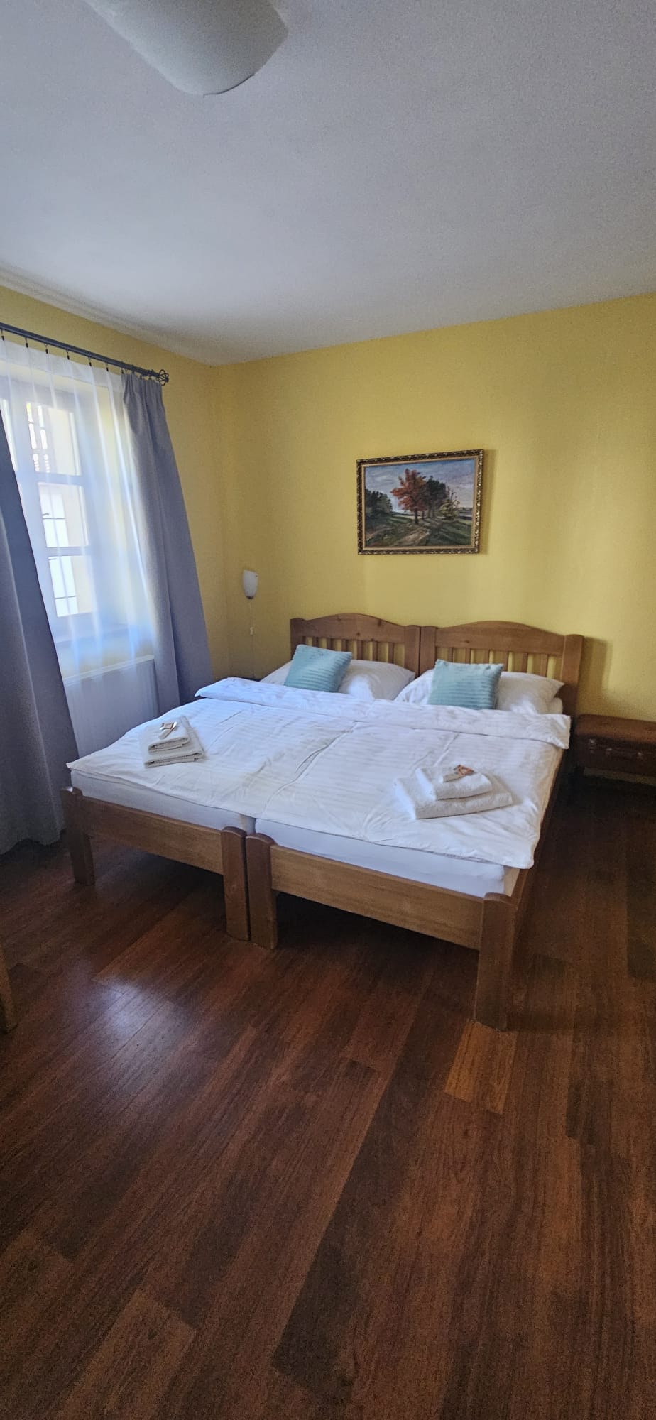 Pokoj s manželskou postelí u okna